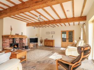 a living room with a fireplace and wooden ceilings at The Dairy in Nottingham