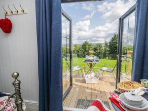 a room with a balcony with a view of a yard at High Rigg Shepherd's Retreat in Brampton
