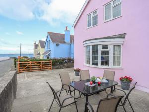 a table and chairs in front of a pink house at The Pink House in Rhosneigr