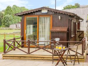 a small cabin with a table and chairs on a deck at Thirley Beck Lodge in Scarborough