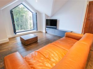 an orange couch in a living room with a large window at Lake View in Windermere
