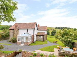 an exterior view of a house with a conservatory at The Old Farmhouse, Upper Pitts in Knighton