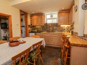 a kitchen with wooden cabinets and a table with chairs at Comers in Ilfracombe