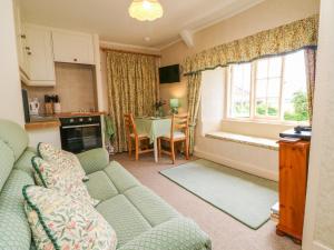 sala de estar con sofá y cocina con mesa en Lower Farm Annexe, en Somerton