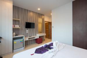 a bedroom with a bed and a tv in a room at Baan Thai Beach Side Residence in Patong Beach