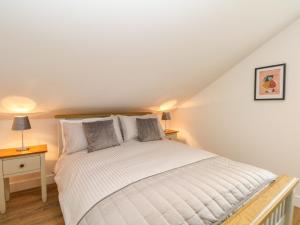 una camera da letto con letto bianco in mansarda di The Croft a Chorley