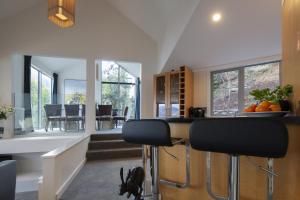 a kitchen with a bar and a dining room with windows at Lago Infinito by Sotheby's Luxury Rental Homes in Queenstown +15 photos