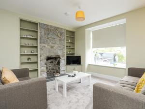 sala de estar con 2 sofás y chimenea en Maes-Yr-Haf en Criccieth