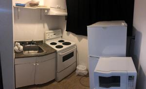 a small kitchen with a stove and a refrigerator at Guest Inn Motel in Trenton