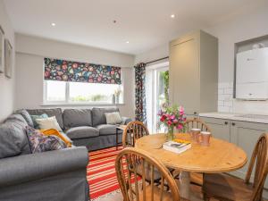a living room with a table and a couch at Braid Apartment in Trearddur