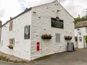 a white building with a red post box in front of it at Church Farm Cottage in Skipton