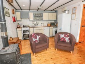 een keuken met 2 stoelen en een fornuis bij Cowslip Cottage in Milford Haven