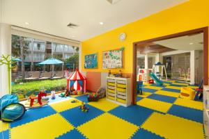 Grand Mercure Phuket Patong في شاطيء باتونغ: غرفة لعب للأطفال مع أرضية صفراء و زرقاء