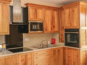 a kitchen with wooden cabinets and a sink at Elmwood in Buxton