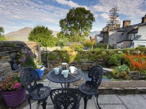 a table and chairs on a patio with a garden at Moelwyn View Cottage in Blaenau-Ffestiniog