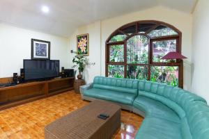 un soggiorno con divano verde e TV di RedDoorz Hostel @ Dago 2 a Bandung