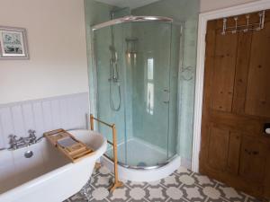 a bathroom with a shower and a bath tub at Moelwyn View Cottage in Blaenau-Ffestiniog