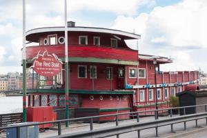 a red building with a sign on the side of a bridge at Den Röda Båten in Stockholm