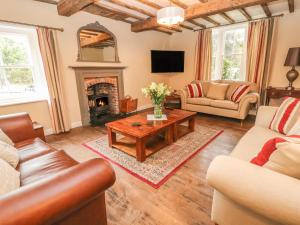 a living room with couches and a fireplace at Rhandregynwen Hall in Llanymynech
