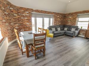 a living room with a brick wall and a table and chairs at Bryn Bethel in Caernarfon