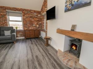 a living room with a fireplace and a tv at Bryn Bethel in Caernarfon