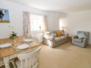 a living room with a table and a couch at Boo Cottage in Taunton
