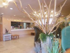 a large vase with branches in the lobby of a store at Apoa Hotel in Yokkaichi