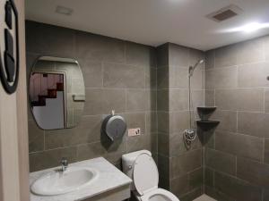 a bathroom with a sink and a toilet and a mirror at Ray Hostel in Chiang Mai