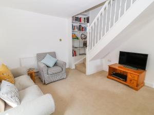 a living room with a couch and a television at Boo Cottage in Taunton