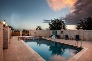 a swimming pool in a backyard with a sunset at La Quinta by Wyndham Odessa North in Odessa