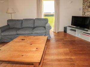 a living room with a couch and a wooden coffee table at The Long Barn in Berwick-Upon-Tweed