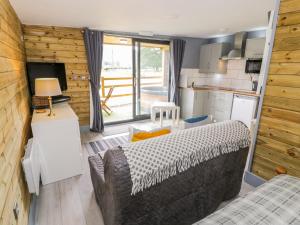 een woonkamer met een bank en een keuken bij Cilan Lodge in Corwen