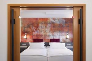 2 Betten in einem Schlafzimmer mit Wandgemälde in der Unterkunft Best Western Plus Arosa Hotel in Paderborn