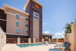 a hotel with a swimming pool and lounge chairs at La Quinta by Wyndham Odessa North in Odessa