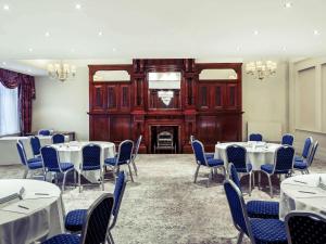 einen Konferenzraum mit Tischen, Stühlen und einem Kamin in der Unterkunft The Grand Hotel Leicester by The Unlimited Collection in Leicester