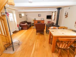 a living room with a wooden table and chairs at The Shippon in Tarporley