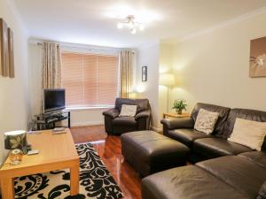 uma sala de estar com um sofá e uma mesa em 7 Riverside Gardens em Inverness
