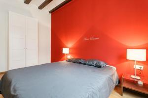 1 dormitorio con una pared roja y 1 cama en Sant Antoni Market, en Barcelona