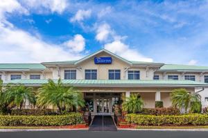 a hotel with a sign on the front of it at MainStay Suites at PGA Village in Port Saint Lucie