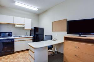 a kitchen with a desk and a tv in a room at MainStay Suites at PGA Village in Port Saint Lucie