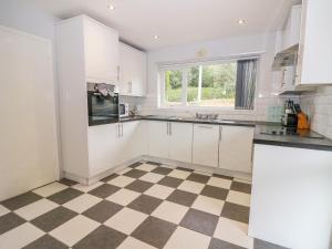 uma cozinha com armários brancos e um piso xadrez em Glynde em Dover