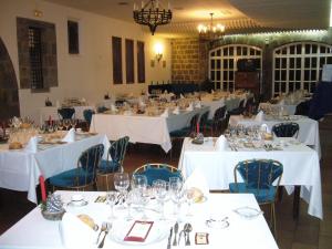 a banquet hall with white tables and blue chairs at Hotel Temple Pradorrey in Astorga