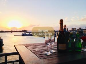 a bottle of wine and glasses on a table with the sunset at Hotel East China Sea in Ishigaki Island