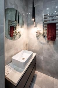 een badkamer met een witte wastafel en een spiegel bij Two bedroom in Lviv