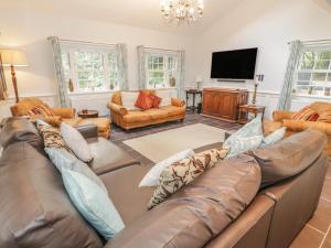 a living room with a couch and a flat screen tv at Bryn Derwen Coach House in Bangor