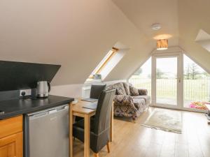 a kitchen and living room with a table and a couch at Little Lochlair in Forfar