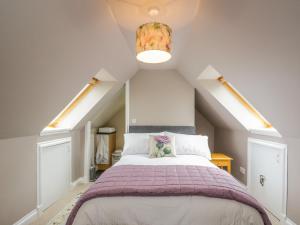 a bedroom with a large bed in a attic at Little Lochlair in Forfar