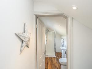 baño con aseo y decoración de estrella en la pared en Southcott Apartment, en Trearddur 21 fotos más
