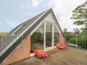 Little Lochlair في فوفار: سقف البيت الزجاجي على منزل به زهور