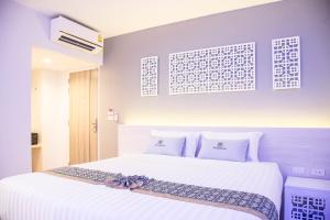 a bedroom with a large white bed with white pillows at Peranakan Boutique Hotel - SHA Plus in Phuket